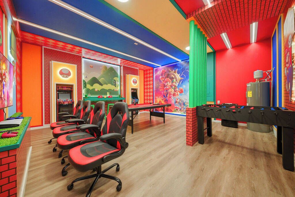 Une pièce aux couleurs vives, avec un baby-foot, des fauteuils de jeu et une table de billard.