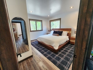 A bedroom with a large bed, two bedside tables, a headboard, and a window. - San Juan Backcountry Lodge, Brand New Luxury lodge near Silverton Colorado (Silverton)
