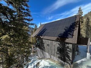 Eine moderne Holzdiele mit geneigtem Dach und Solaranlage.