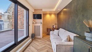 Una sala de estar moderna con un ventanal grande, chimenea, sofá y una mesita baja con adornos.