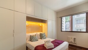 A hotel room with a bed, a window with a view of buildings, and a built-in wardrobe. - Near Rodrigo de Freitas Lagoon Pc308 (Rio de Janeiro)