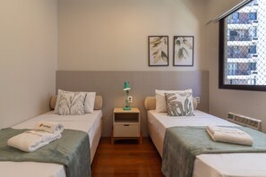 A hotel room with two single beds, a nightstand with a lamp, and a window with a view of a building. - Near Rodrigo de Freitas Lagoon Pc308 (Rio de Janeiro)