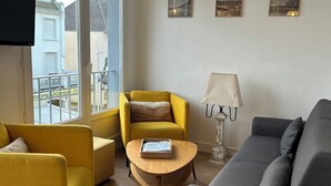 A living room with a yellow armchair, a grey sofa, a wooden coffee table, and a lamp. - In the heart of Hardelot, 2 minutes' walk from the beach. Renovated 5-person apartment (Neufchâtel-Hardelot)
