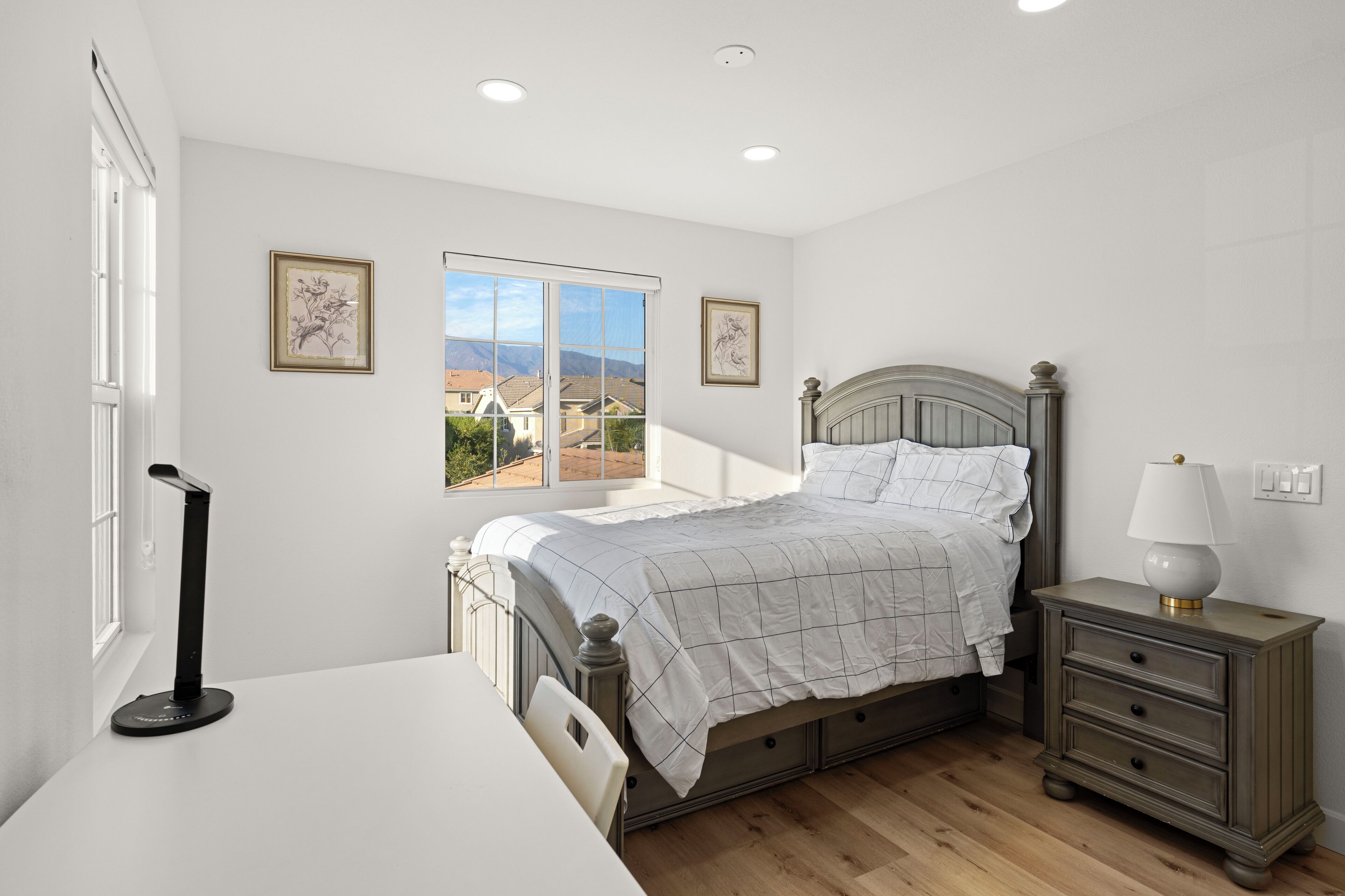 Une chambre à coucher avec un lit, une table de chevet et une fenêtre donnant sur un beau paysage.