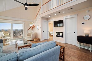 TV, fireplace, books - Pickled Pelican: Bright and Airy Oceanfront Home (Oak Island)