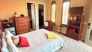 Une chambre à coucher avec un lit, une commode et un téléviseur posé sur un meuble.