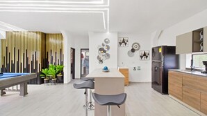 A modern kitchen with a central island, bar stools, and a pool table. - 2BR w Pool Table 1 Block from Lleras (Medellín)