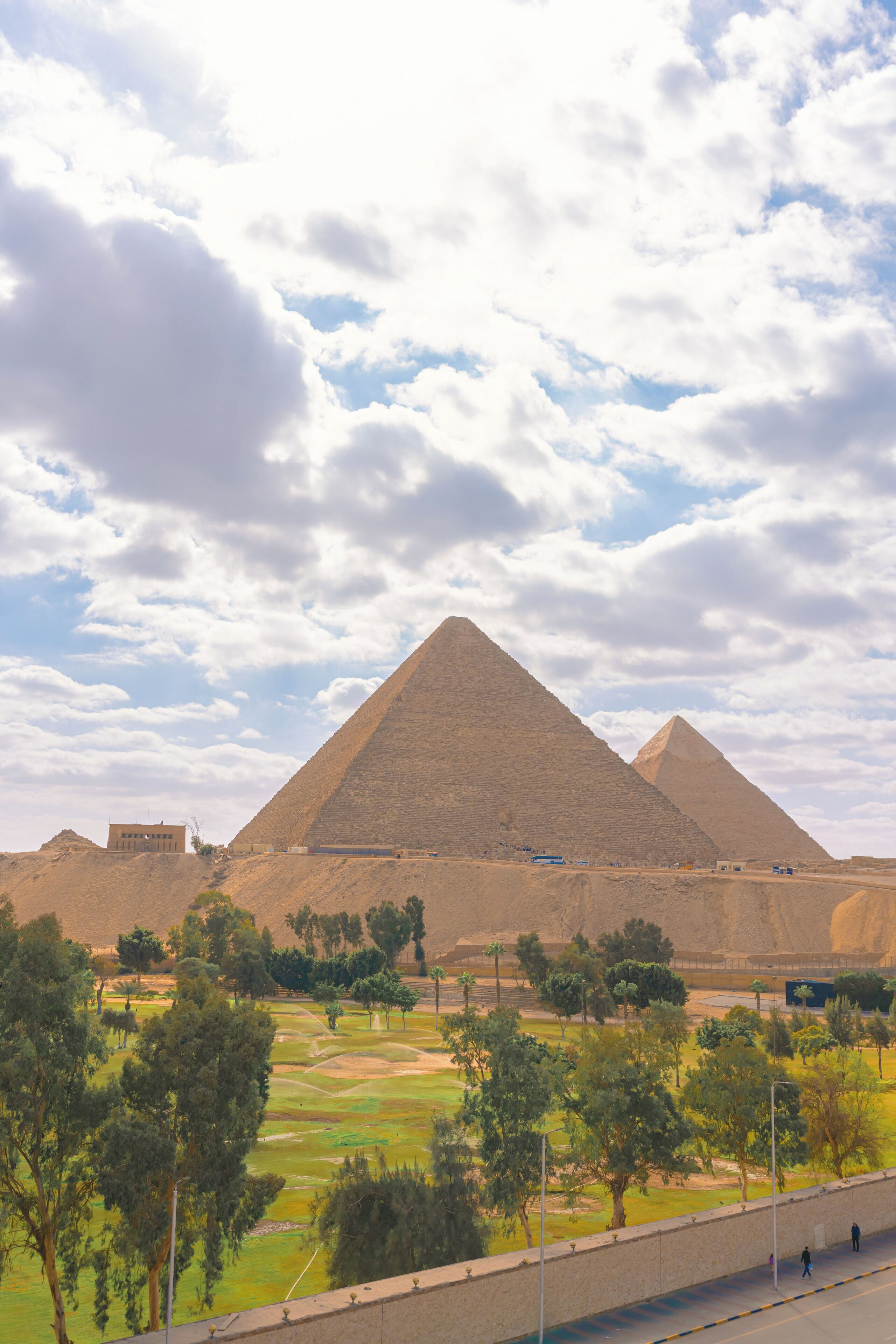 A large pyramid structure with a clear sky and clouds in the background.