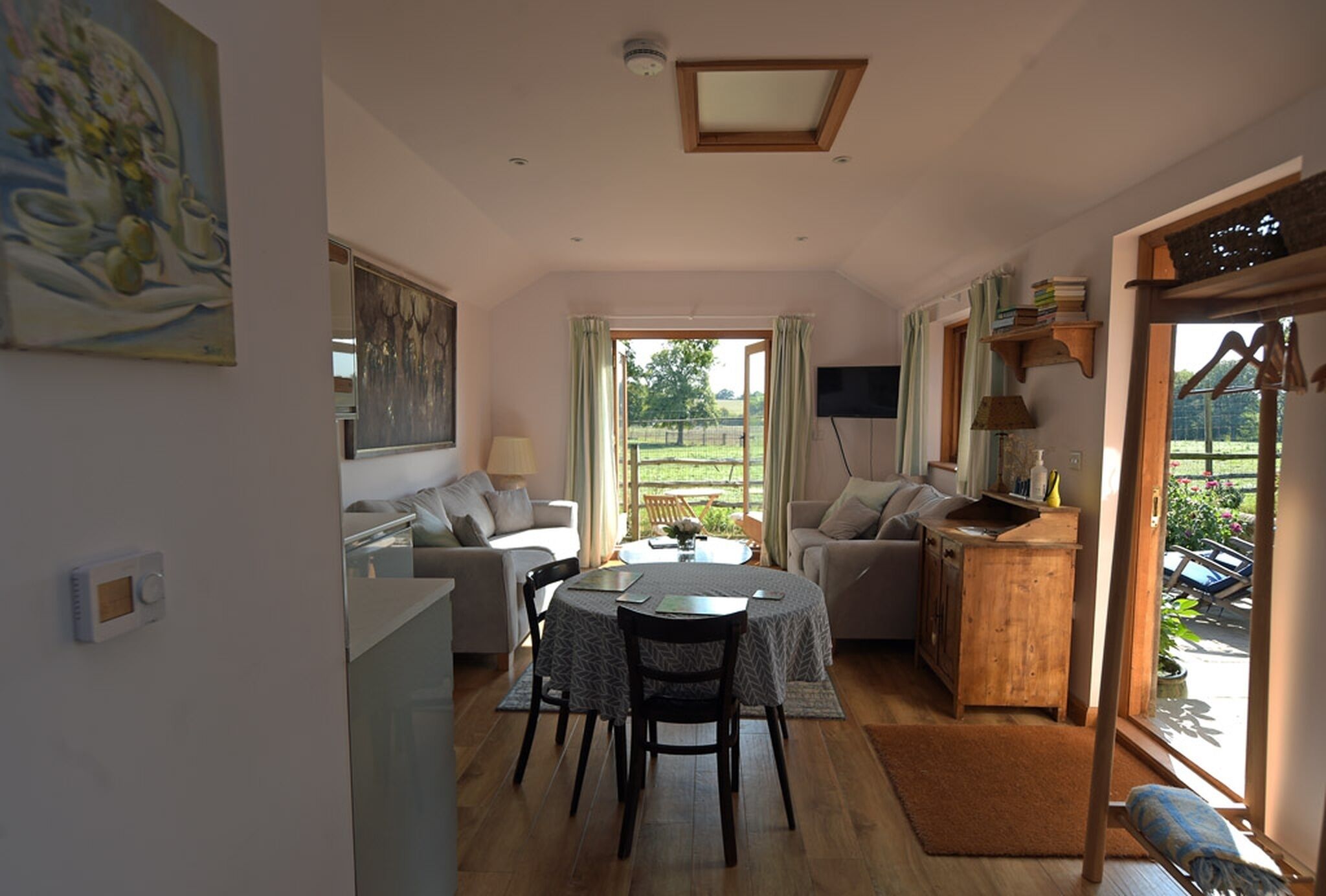 A cozy living room with a dining area, a television, and a view of the outdoors.