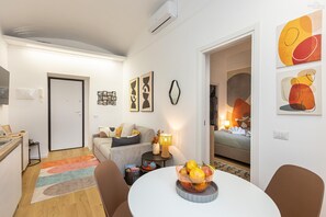 Un salon moderne comprenant un coin repas, une cuisine et une chambre.