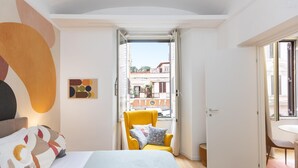 A bedroom with a bed, a chair, a window, and a door. - Rental in Rome Vic House (Rome)