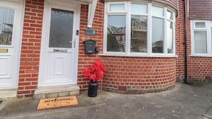 A red brick house with a white front door, a mailbox, and a welcome mat. - Seaside Serenity (Lytham St. Anne's)
