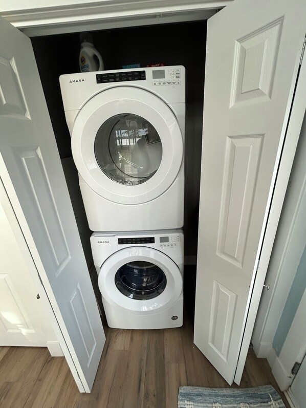 A compact laundry room with two stacked front-loading washing machines.
