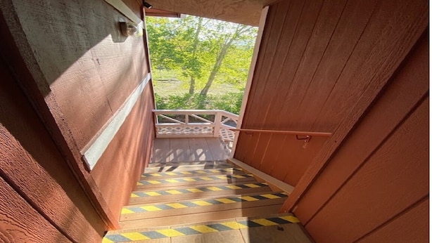 A wooden staircase leading to a balcony with a railing. - Country Lodge (Big Bear Lake)