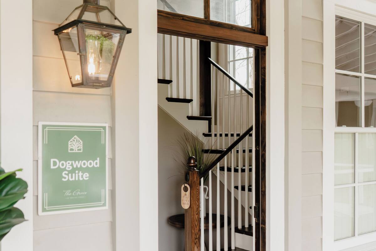 A staircase leading to a room with a sign indicating 'Dogwood Suite.'