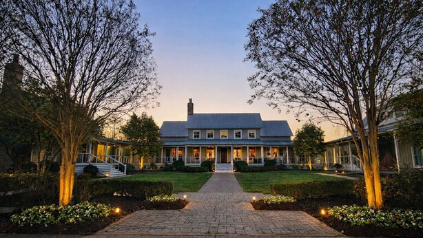 A two-story house with a front porch, a driveway, and a well-maintained lawn. - The Inn at The Grove at Whites Creek (Whites Creek)
