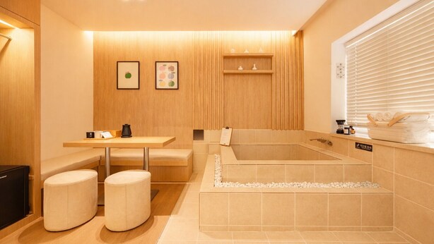 Un baño moderno con una bañera, un tocador con un lavamanos y dos taburetes.
