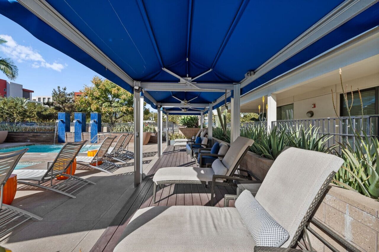 Un'area lounge esterna coperta, con poltrone e piscina.