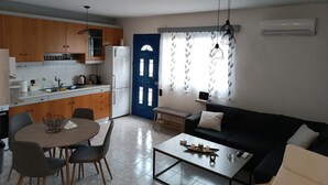 Een compacte wooneenheid met een kitchenette, een eethoek en een zithoek.
