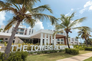 A modern hotel with a prominent sign reading 'THE TOWERS ATANA'. - NOK Cozy 1BR Apartment the towers By Vistacana (Punta Cana)