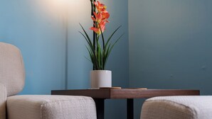 Een kamer met een bank en een kleine tafel met een bloempot.