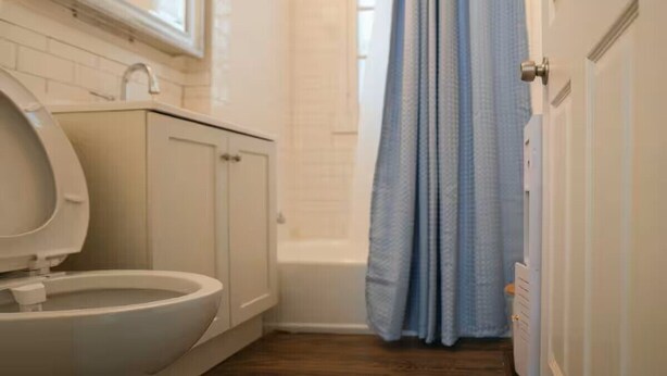 Une salle de bain comprenant des toilettes, un lavabo et un espace douche.