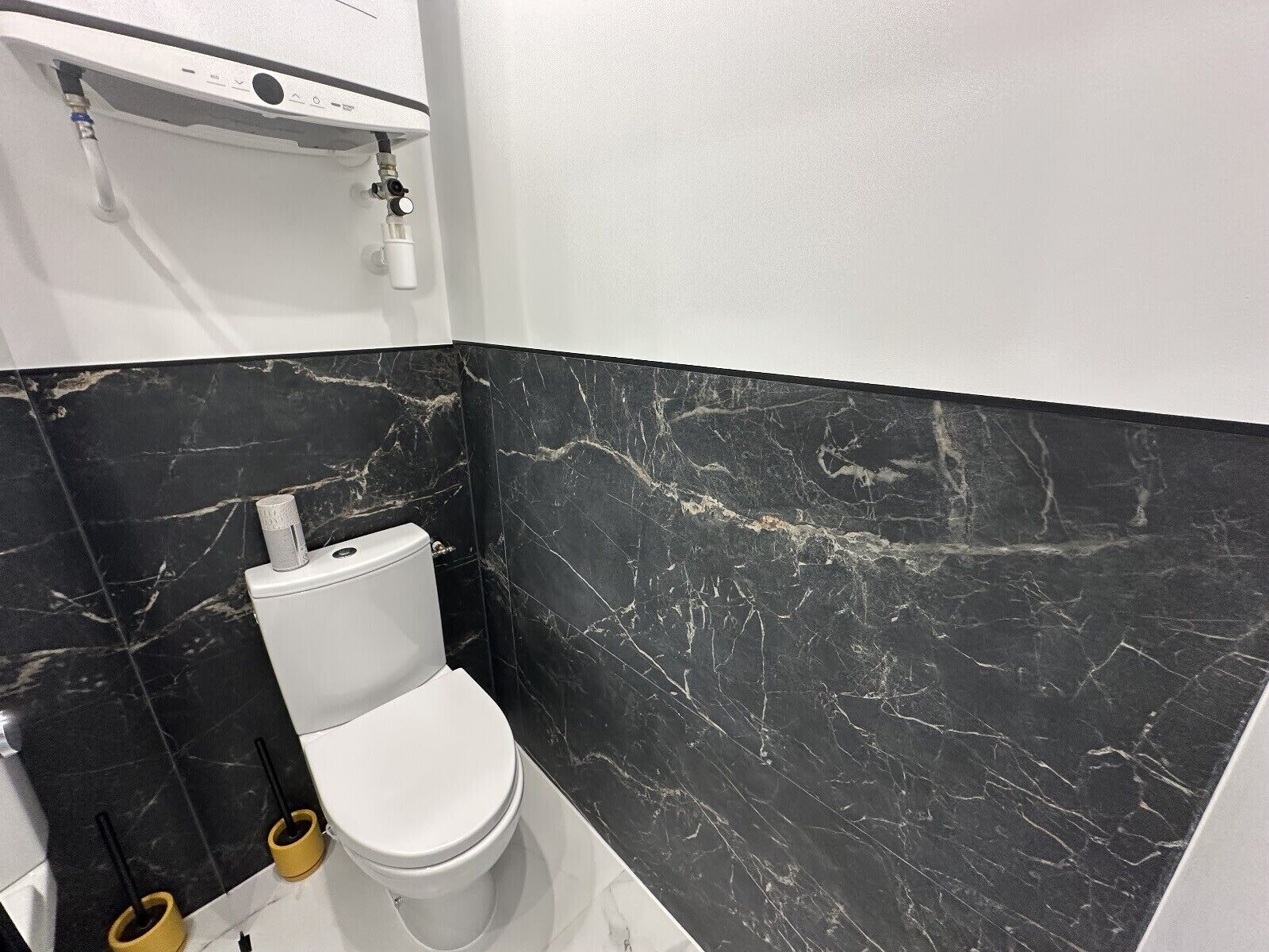 Une salle de bain avec des toilettes, un lavabo et une douche.