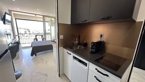 Una cucina compatta con macchina del caffè, lavello e lavastoviglie.