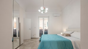A bedroom with a bed, a mirror, a door, and a ceiling light fixture. - Apartment 'Bellavista Sul Mare' with Sea View, Wi-Fi and Air Conditioning (Palermo)