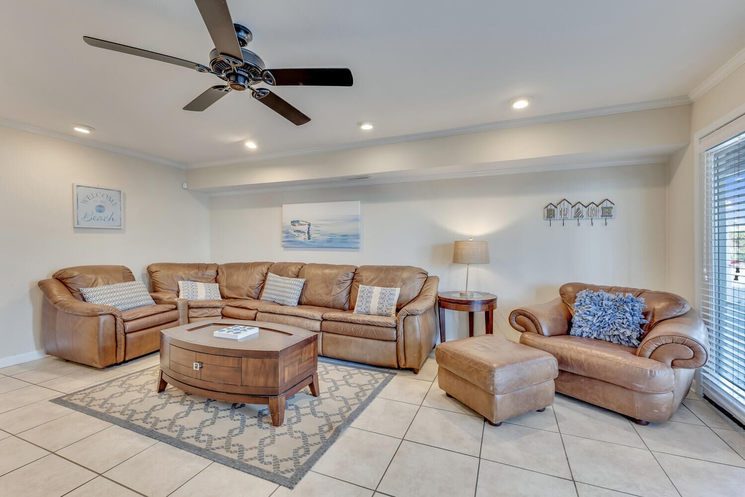 A living room with a brown leather sectional sofa, a wooden coffee table, and a single armchair.