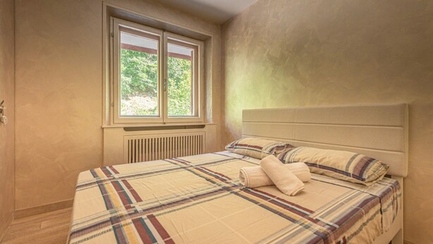 A bedroom with a bed, a window, and a radiator. - La Casina - Pian de` Valli (Pian De` Valli)