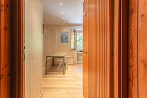 Un couloir avec une porte en bois, une table et un radiateur.