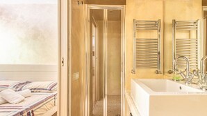 A hotel room with a bed, a shower area, and a bathroom with a sink and mirror. - La Casina - Pian de` Valli (Pian De` Valli)