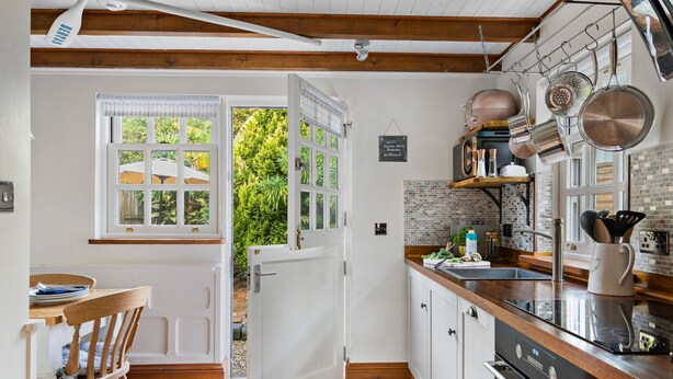 Una cocina moderna con encimera de madera, electrodomésticos de acero inoxidable y vistas al exterior.