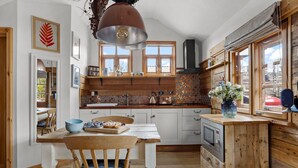 Una cocina con armarios de madera, una isla central, una estufa y un ventanal con vistas.