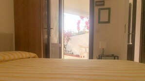 Ett hotellrum med en säng, en stol och ett bord.