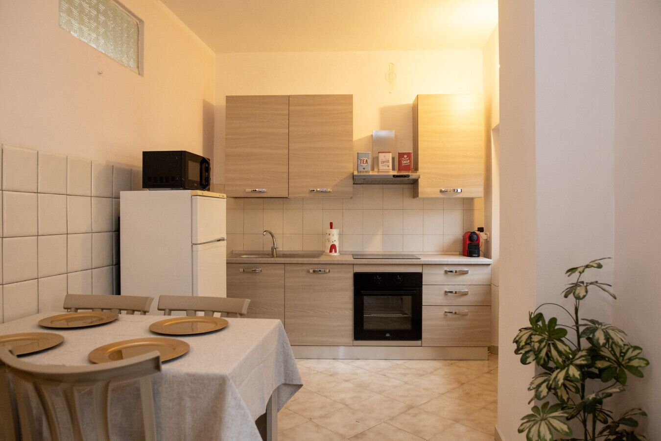 Une cuisine compacte avec un coin repas, comprenant un réfrigérateur, une cuisinière, un évier et des placards.