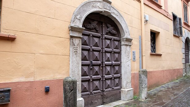 A stone arched entrance with a wooden door, flanked by two stone pillars, leading to a cobblestone street. - Casa Arduini - Supino (Supino)