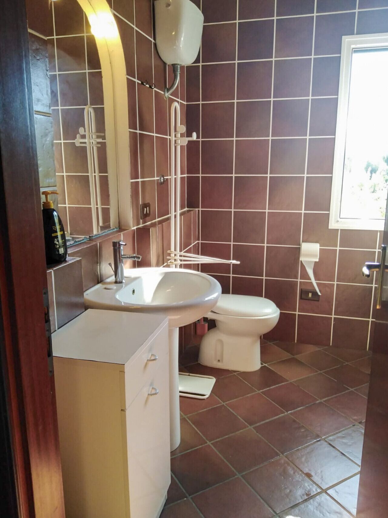 A bathroom with a white sink, a toilet, and a mirror.