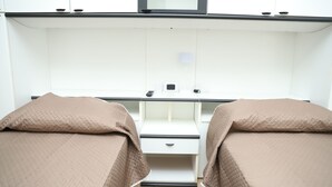 A bedroom with two beds, a desk, and a mirror. - La casetta sul mare (San Lucido)