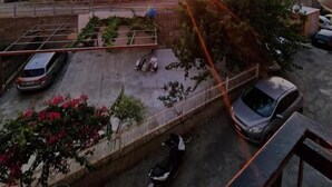 A parking area with cars and a building in the background during sunset. - La casetta sul mare (San Lucido)
