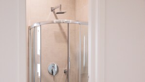 Ein modernes Badezimmer mit einer Duschkabine, einer Toilette und einem Waschbecken.