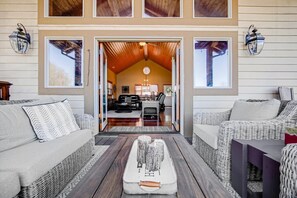 A cozy living area with wicker furniture, a wooden coffee table, and a view into the dining area. - Breathtaking 2-Bedroom Mountain Condo - 15 Mins from Harrah's Casino (Whittier)