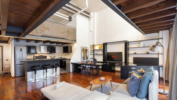 A modern living space with a kitchen, dining area, and a cozy seating area with a sofa and a coffee table. - Loft Bandiello by BarbarHouse (Milano)