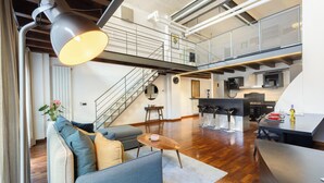 A modern living space with a staircase, a dining area, and a kitchen. - Loft Bandiello by BarbarHouse (Milano)