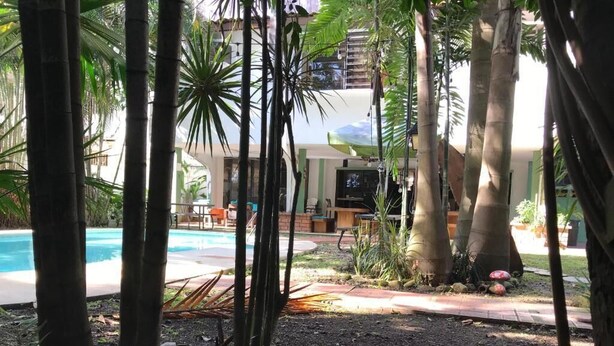 Zona de piscina con una silla de descanso y un televisor.