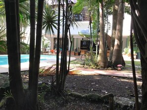 A pool area with a lounge chair and a television. - Cultura Humana Guesthouse (Panama City)