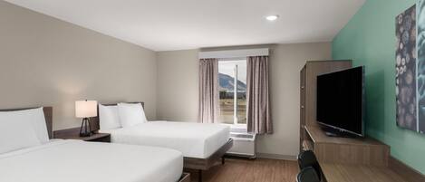 A hotel room with two beds, a flat-screen TV, a desk, and a window with curtains.