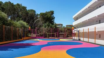 Un parque infantil con piso de goma de colores y vallas de seguridad.