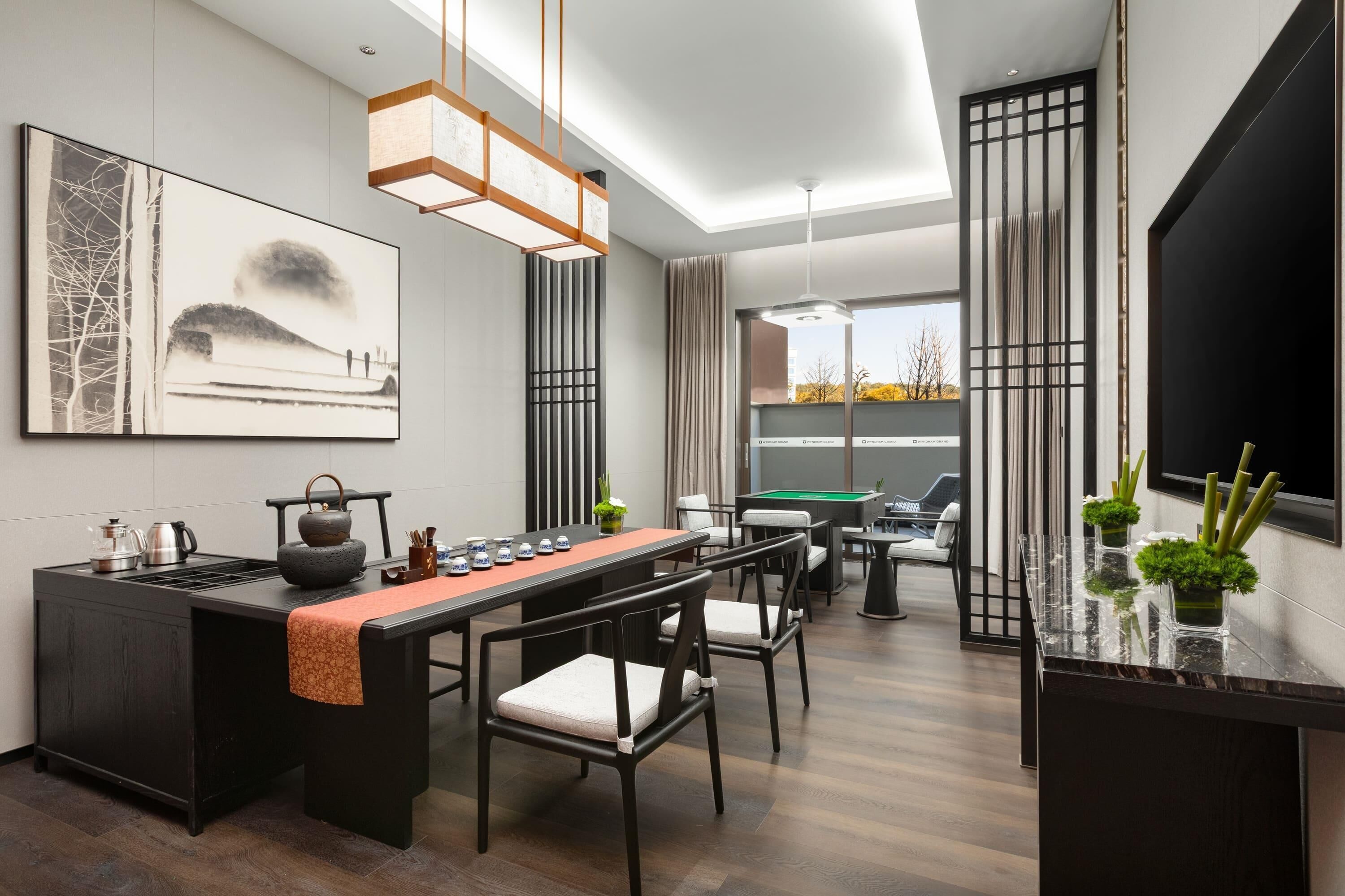 Una cocina moderna con zona de comedor, que incluye una mesa larga, sillas, una isla de cocina y un amplio ventanal con vistas.